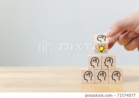 Hand flip over wooden cube block with head human symbol and light bulb icon Hand flip over wooden cube block with head human symbol and light bulb icon 71574877