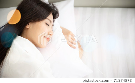 Young asian beautiful woman happy sleep on bed in morning time Young asian beautiful woman happy sleep on bed in morning time 71574878