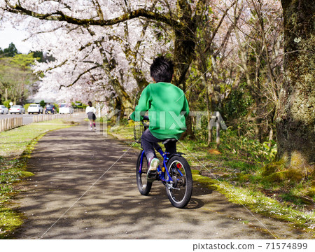 A boy riding a bicycle 71574899
