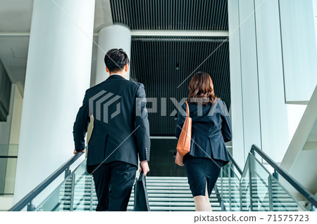 Male and female business team climbing stairs in the office Male and female business team climbing stairs in the office 71575723