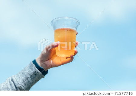 Woman drinking beer on the barbecue 71577716