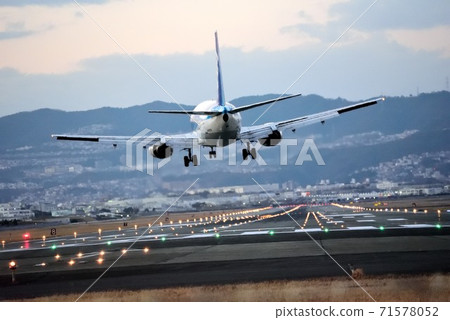 From Itami Airport in the New Year, an airplane just before landing in the evening, from the bank of the Senri River 71578052