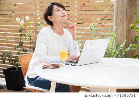 女人看著一台筆記本電腦在戶外 女人看著一台筆記本電腦在戶外 71580751