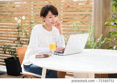 女人看著一台筆記本電腦在戶外 女人看著一台筆記本電腦在戶外 71580752