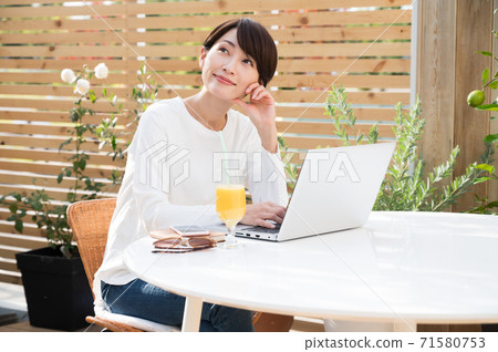女人看著一台筆記本電腦在戶外 女人看著一台筆記本電腦在戶外 71580753