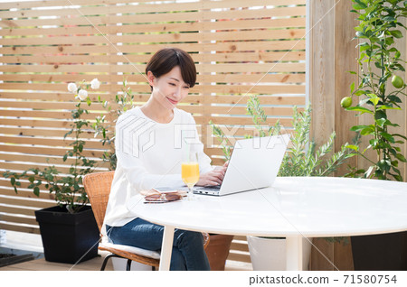女人看著一台筆記本電腦在戶外 71580754