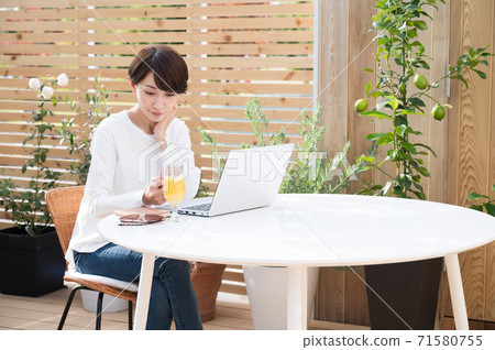 女人看著一台筆記本電腦在戶外 女人看著一台筆記本電腦在戶外 71580755