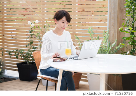 女人看著一台筆記本電腦在戶外 71580756