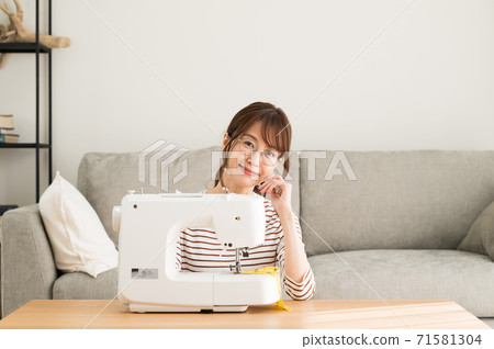 戴著眼鏡坐在縫紉機前的女人 戴著眼鏡坐在縫紉機前的女人 71581304