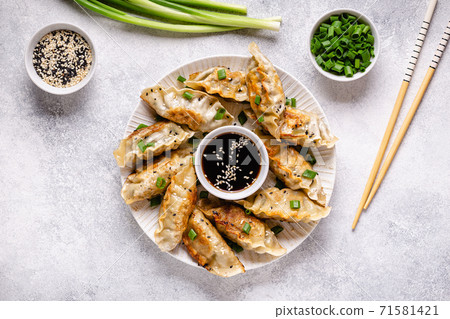 Fried dumplings gyoza with soy sauce, and chopsticks. 71581421