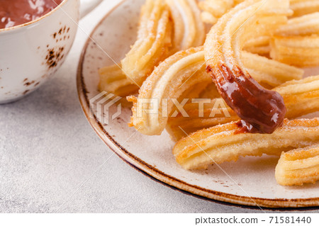 churros with powdered sugar and chocolate sauce churros with powdered sugar and chocolate sauce 71581440