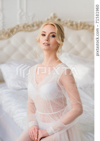 Morning of a beautiful young bride in a boudoir dress. Morning of a beautiful young bride in a boudoir dress. 71581960