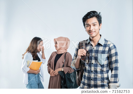 Portrait of Happy young man university carrying bags and campus young people chatting Portrait of Happy young man university carrying bags and campus young people chatting 71582753