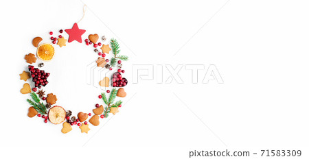 Christmas Decorative wreath made of festive elements, oranges, cranberries and gingerbread cookies on white background. Christmas Decorative wreath made of festive elements, oranges, cranberries and gingerbread cookies on white background. 71583309