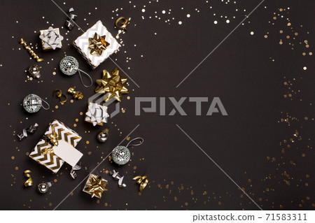 Gold and silver decorations, mirror disco balls, gifts on dark black background. Christmas, winter, new year concept. Gold and silver decorations, mirror disco balls, gifts on dark black background. Christmas, winter, new year concept. 71583311