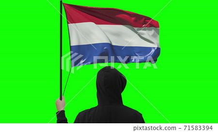 Waving flag of Netherlands and unknown man wearing black, isolated on green background 71583394