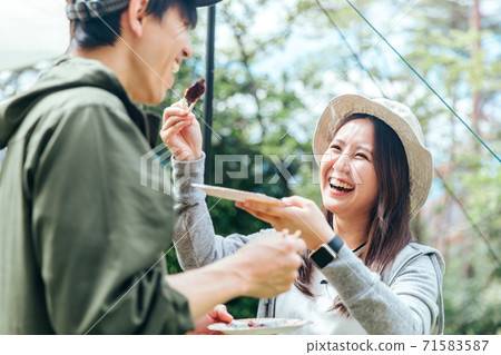 Men and women doing BBQ at the camp 71583587