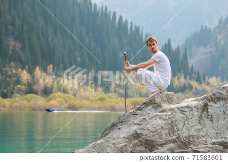 A man with a beard lowered his battle sword. Male defeat. 71583601