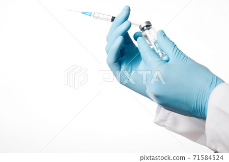 Close up hands of doctor in blue latex glove with glass ampoule and syringe on white background. 71584524
