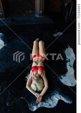 Sexy fashion model with blond hair, posing in bedroom, wearing red lingerie Sexy fashion model with blond hair, posing in bedroom, wearing red lingerie 71584805