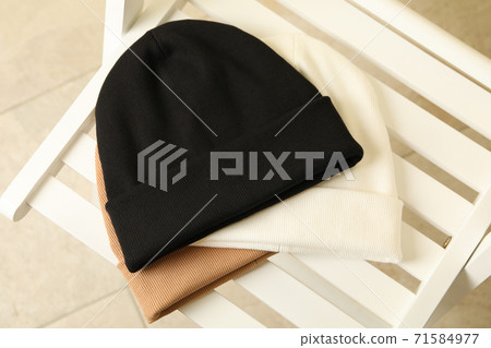 Three stylish beanies on wooden chair, top view 71584977