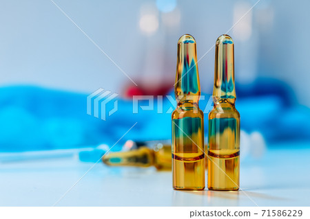 Vial of vaccine bottle with a syringe close up 71586229