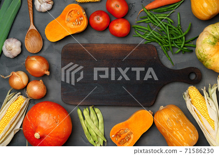 Autumn background with fresh vegetables and wooden cutting board Autumn background with fresh vegetables and wooden cutting board 71586230