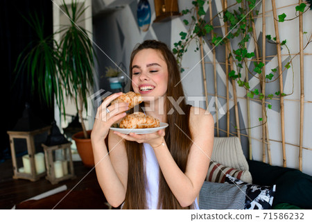 Portrait of beautiful woman in lingerie, white swimsuit with a sweet cake, croissant Portrait of beautiful woman in lingerie, white swimsuit with a sweet cake, croissant 71586232