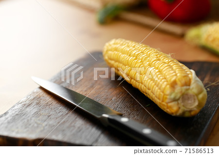 Corn cobs on wooden kitchen table close up Corn cobs on wooden kitchen table close up 71586513