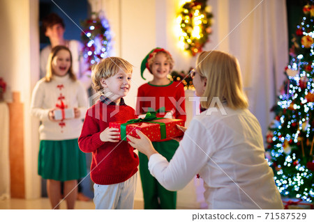 Family on Christmas day. Kids with gifts at door. 71587529