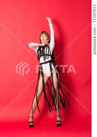 Young beautiful dancer posing in studio on red background 71587615