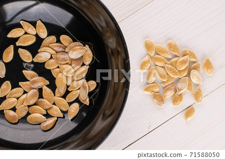 Pumpkin seed on white wood Pumpkin seed on white wood 71588050
