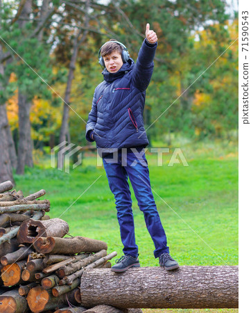 teenager listening to music in headphones, relaxing outdoor, walks in autumn city park, beautiful nature teenager listening to music in headphones, relaxing outdoor, walks in autumn city park, beautiful nature 71590543