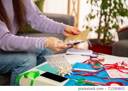 Woman making greeting card for New Year and Christmas 2021 for friends or family, scrap booking, DIY 71590601