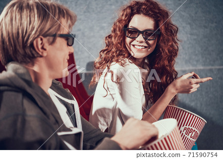 Red girl in 3D glasses laughs at joke in cinema. Red girl in 3D glasses laughs at joke in cinema. 71590754