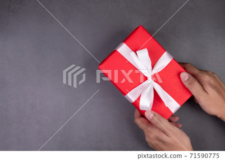 Hand of man holding gift giving on cement floor in Christmas day or holiday, present box. 71590775