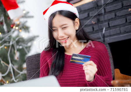 Young asian woman online shopping in Christmas with credit card on laptop computer. Young asian woman online shopping in Christmas with credit card on laptop computer. 71590781