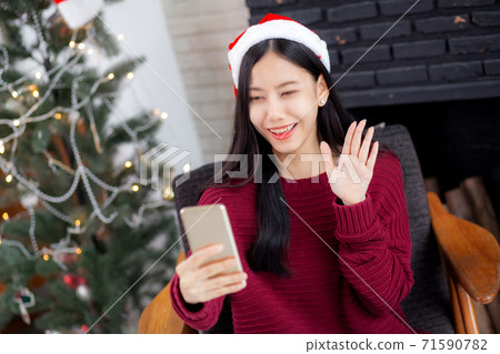 Young asian woman selfie video call online with friends in Christmas day on phone at home. Young asian woman selfie video call online with friends in Christmas day on phone at home. 71590782