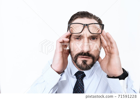 A bearded man looks at camera and feels migraine. A bearded man looks at camera and feels migraine. 71591228