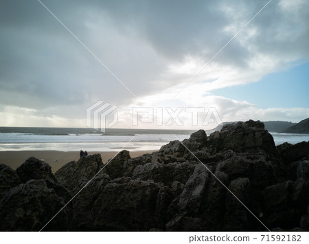 Overlooking the ocean from the rocks on a cloudy day at Caswell Bay Beach towards winter. 71592182