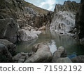A large rock pool sitting between the tides with smooth rocks from sea erosion. Location: Caswell Bay, Gower, Wales, UK 71592192