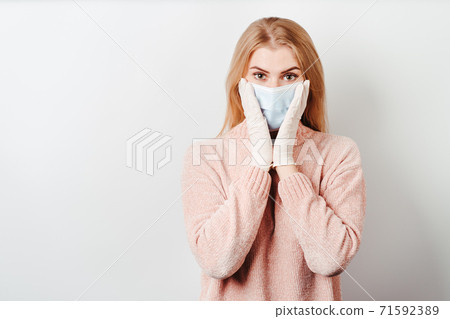 Shocked overwhelmed woman wearing a face mask Shocked overwhelmed woman wearing a face mask 71592389