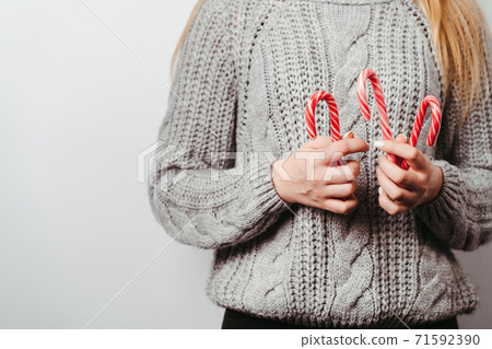 Christmas time. Woman holding candy canes Christmas time. Woman holding candy canes 71592390