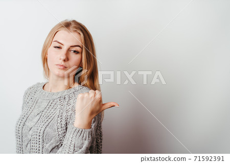 Pensive skeptical woman pointing on empty space Pensive skeptical woman pointing on empty space 71592391