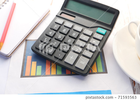 Close up of blue calculator and notepad on color background  71593563