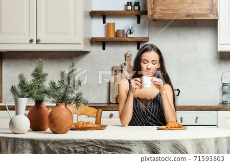 Sleepy mixed race woman drinking fresh coffe in the kitchen Sleepy mixed race woman drinking fresh coffe in the kitchen 71593803
