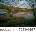 Looking down on Caswell Bay Beach from the Gower Coastal Path in late Autumn. Trees without leaves and rich colours. 71594467