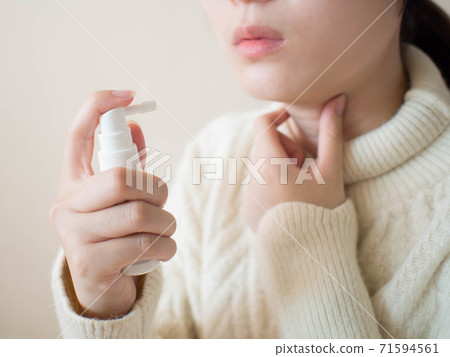 Sick woman using spray medication for relief of painful sore throats, cough, pharyngitis and hoarseness. Pharmaceutical product. Health care and medical concept. Close up. 71594561