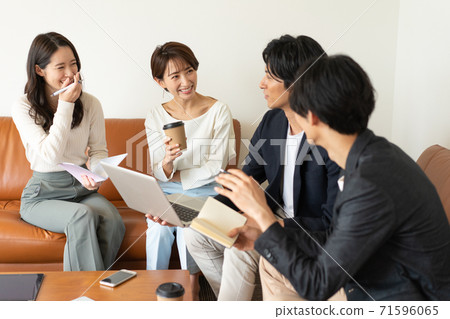 四個年輕人和婦女坐在營業所的沙發上和開會 四個年輕人和婦女坐在營業所的沙發上和開會 71596065
