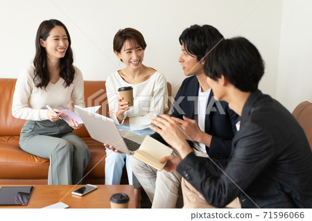 四個年輕人和婦女坐在營業所的沙發上和開會 71596066